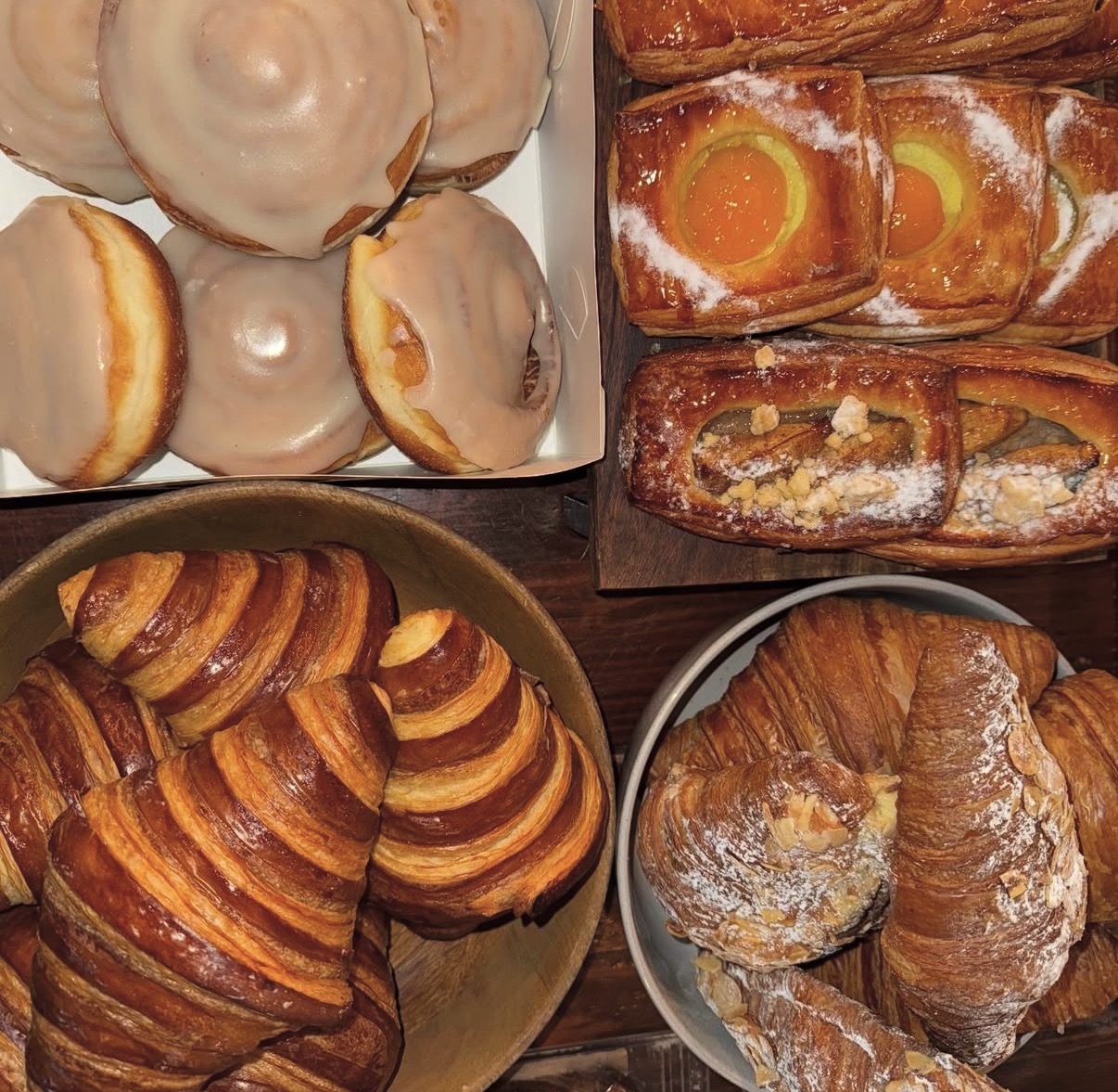 Tray of fresh croissants, cinnamon scrolls and iced donuts