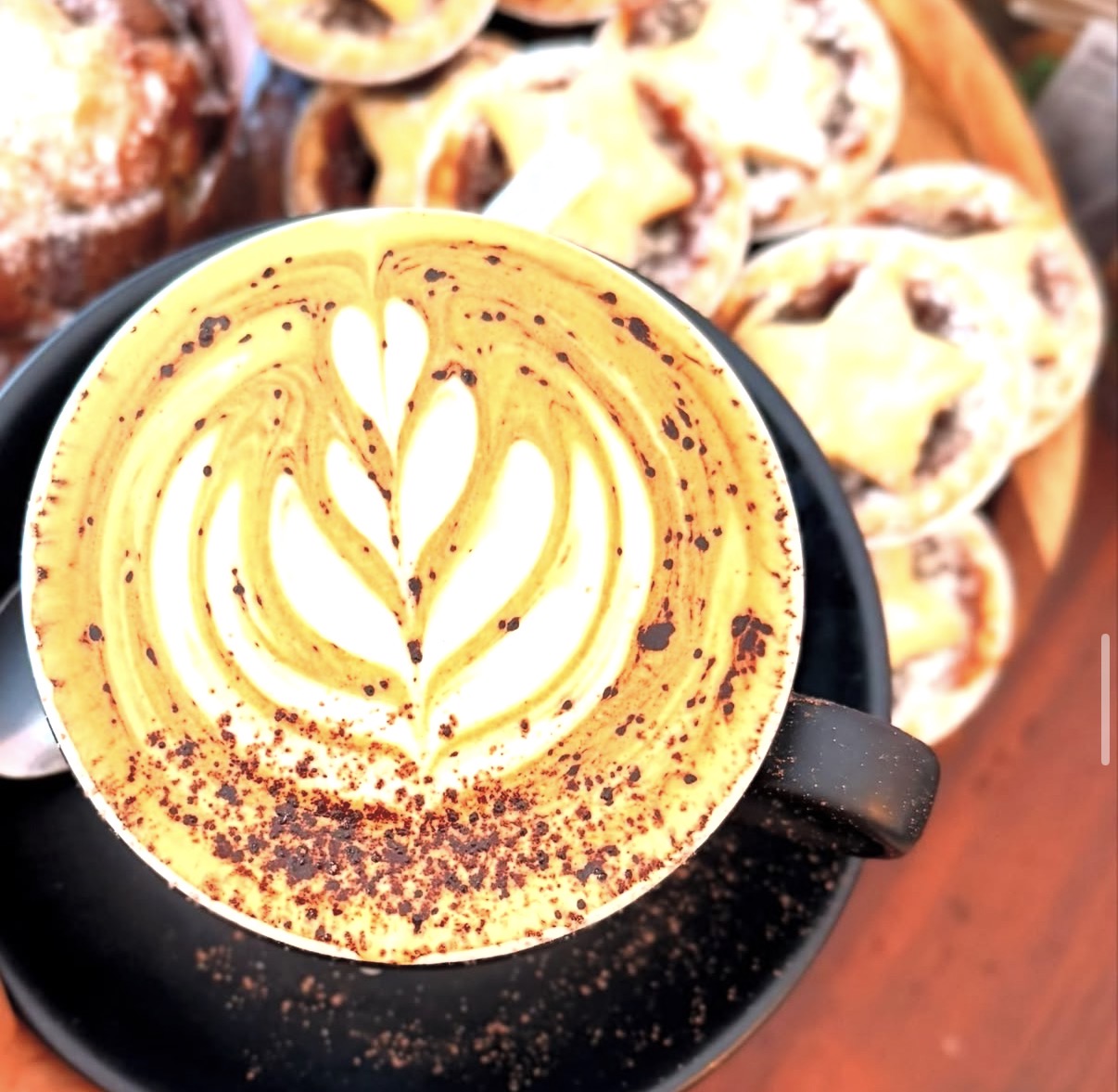 Flat white with latte art and pastries