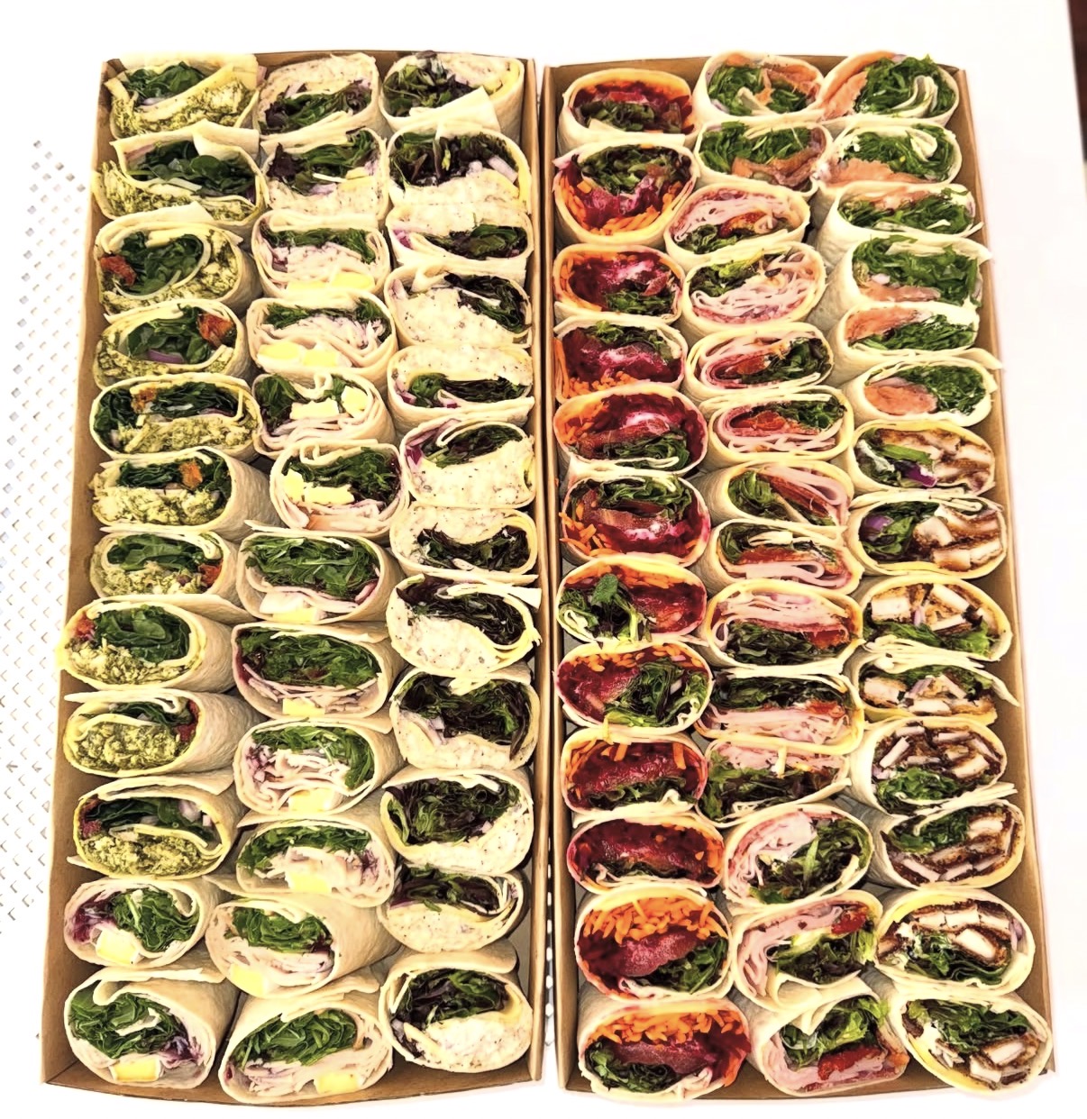 Rows of cut wraps in catering boxes
